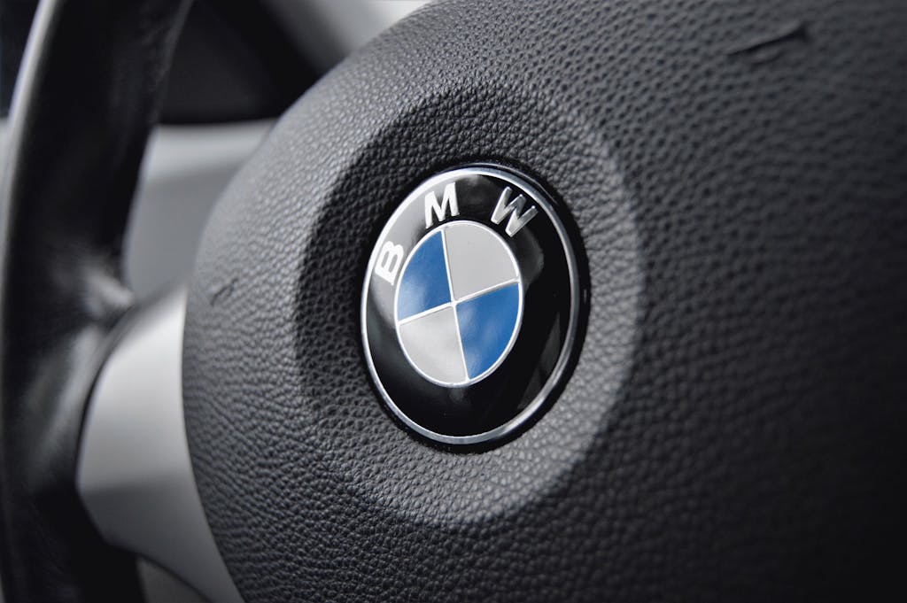 Detailed view of a BMW steering wheel with focus on the emblem showcasing luxury and design.